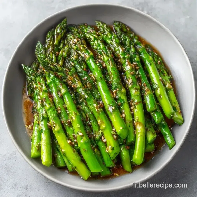 Asperges vert tendre dress&eacute;es avec soin, surmont&eacute;es de zestes de citron jaune et de poivre noir sur une assiette &eacute;pur&eacute;e.