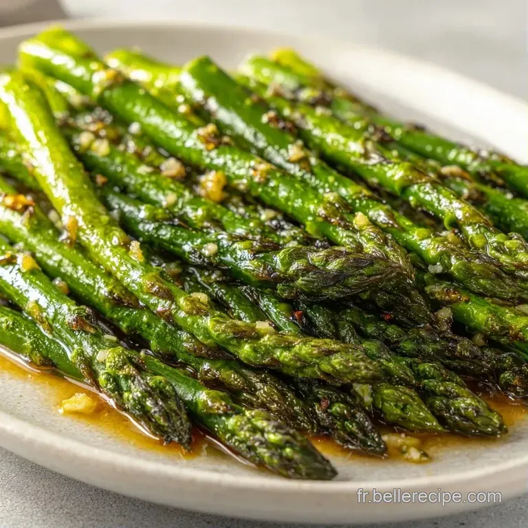 Asperges croquantes vert tendre align&eacute;es sur une assiette blanche, parsem&eacute;es de grains de sel et d'un filet de citron.
