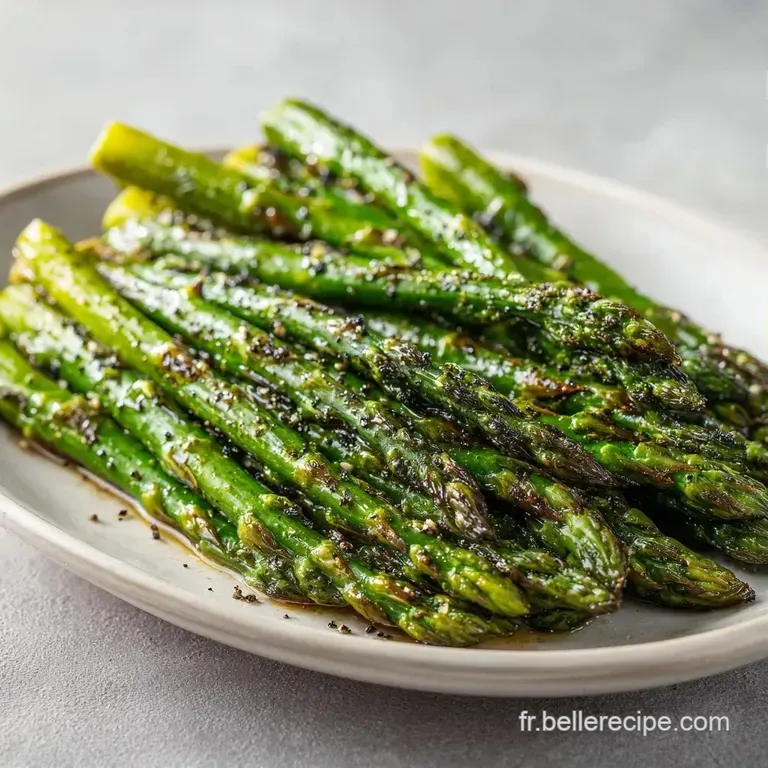 Asperges tendres et luisantes dress&eacute;es avec soin sur une assiette sombre, agr&eacute;ment&eacute;es de zestes de citron jaune frais.