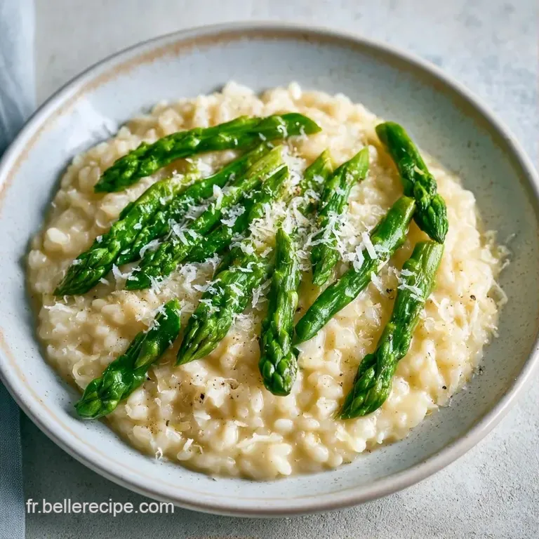 Un d&ocirc;me de riz onctueux dans une assiette blanche, garni d'asperges croquantes et d'un filet d'huile d'olive dor&eacute;e.